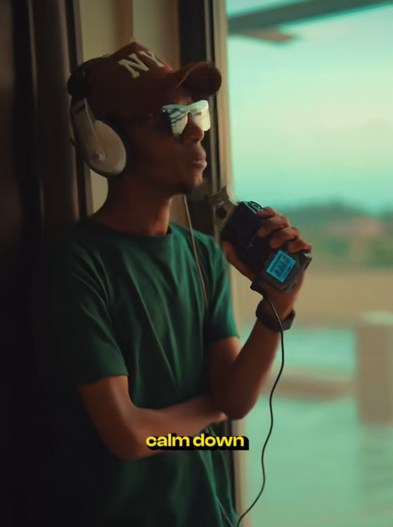 A young Hausa artist holding a phone and studio headphones, ready to upload their single to streaming platforms.